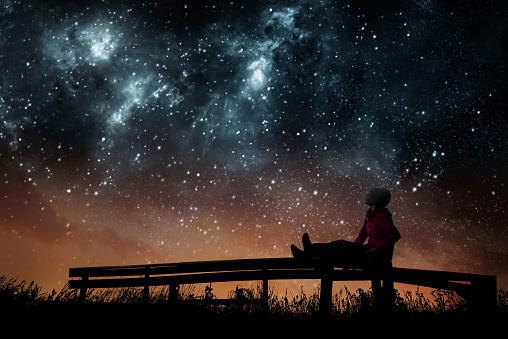 Girl watching the stars in night sky l'astrologie trouver des reponses a mes questions